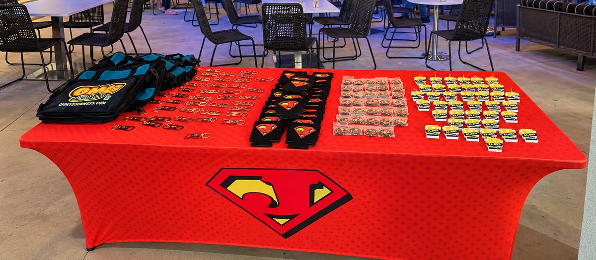 Branded sponsor table with a custom table cover, bags, badges and giveaway items